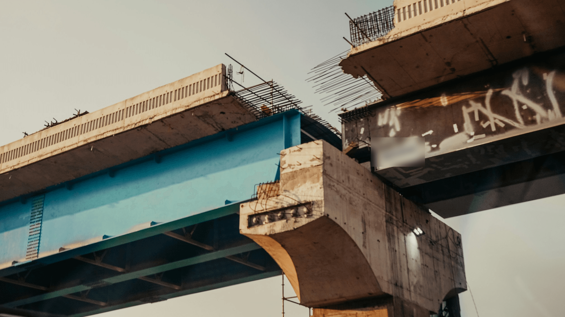 Two halves of an unfinished elevated road that stop short of meeting, with bare rebar sticking out of both ends, a picture of work done halfway